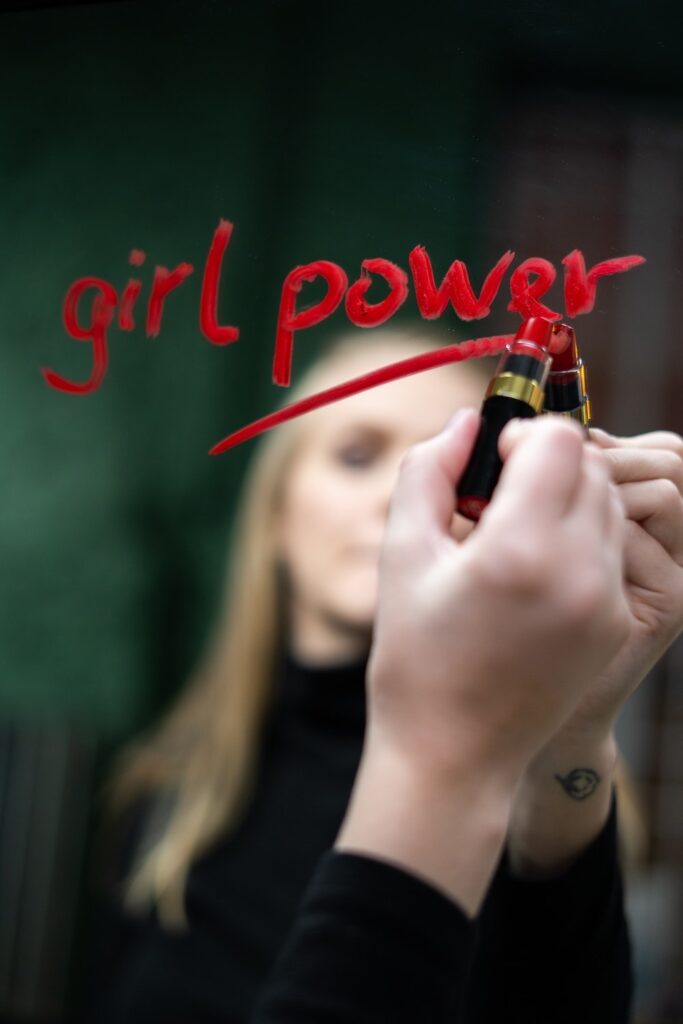 Le slogan Girl Power tracé au rouge à livre sur un miroir