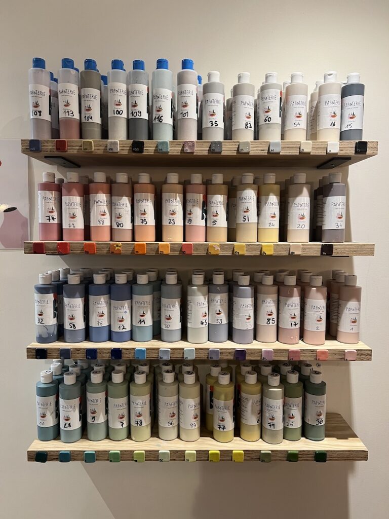 Présentoir avec une quarantaine de bidons de peinture de couleur