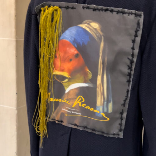 Veste Renoma avec au dos un montage photo représentant la jeune fille à la perle de Vermeer avec une tête de poisson