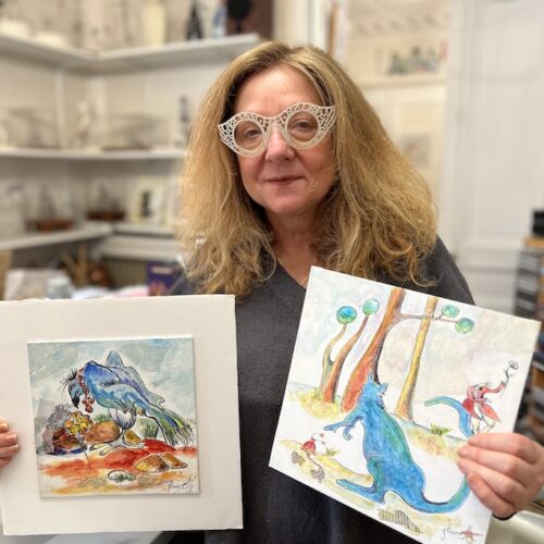 Portrait de Caroline Glass présentant deux dessins colorés d'animaux