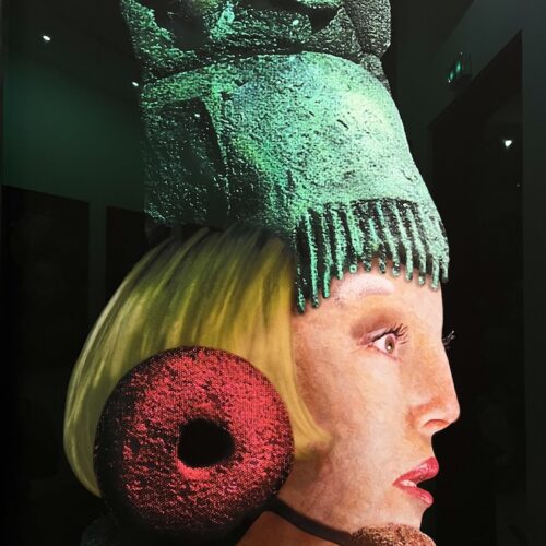 Détail d'un grand format présentant de profil un visage de femme avec une coiffe verte.