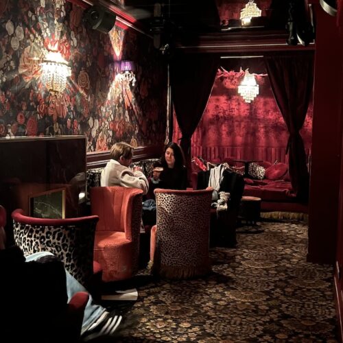 Partie intimiste du Yago Pigalle avec fauteuils et banquettes motifs léopard, lumière tamisée et au fond, une alcôve pour se lover.