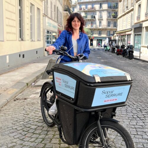 Marion Oudin sur son vélo électrique floqué aux couleurs de Soeurs Serrure