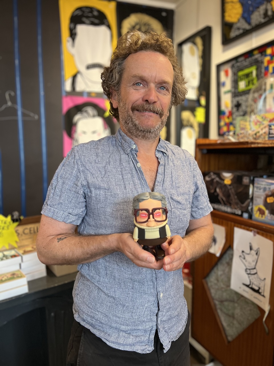 Portrait de Mathieu Gibault avec dans les mains une figurine de Marguerite Duras