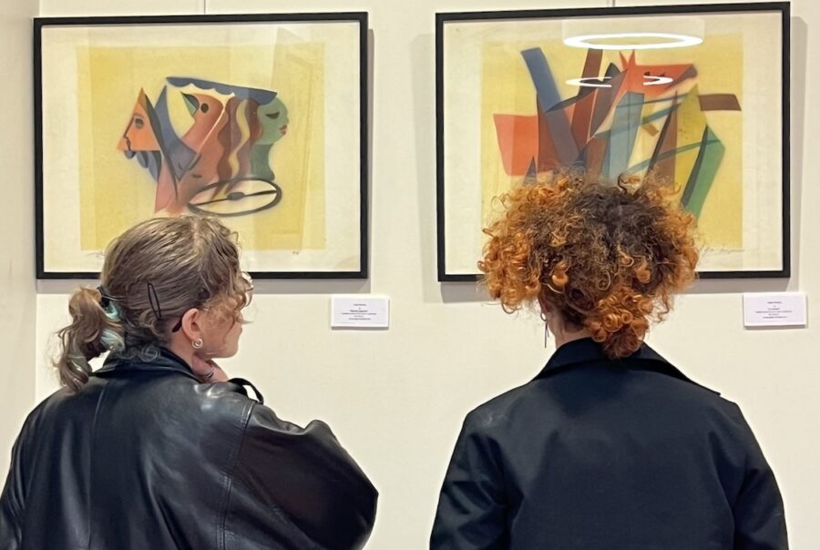 Deux jeunes adultes devant les tableaux d'Edgar Stoëbel