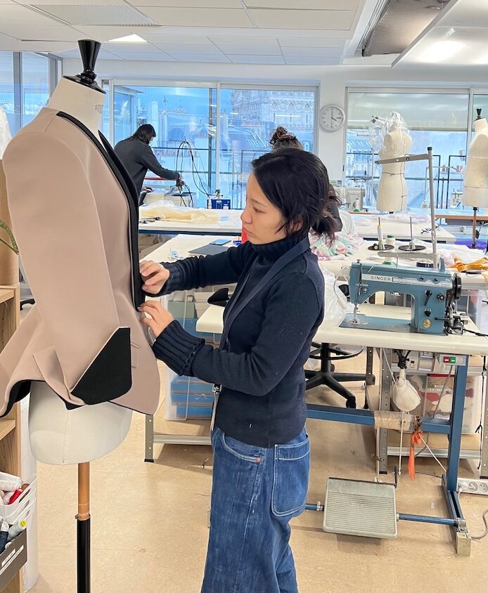 Intérieur de l'atelier avec a premier plan une veste bicolore sur mannequin