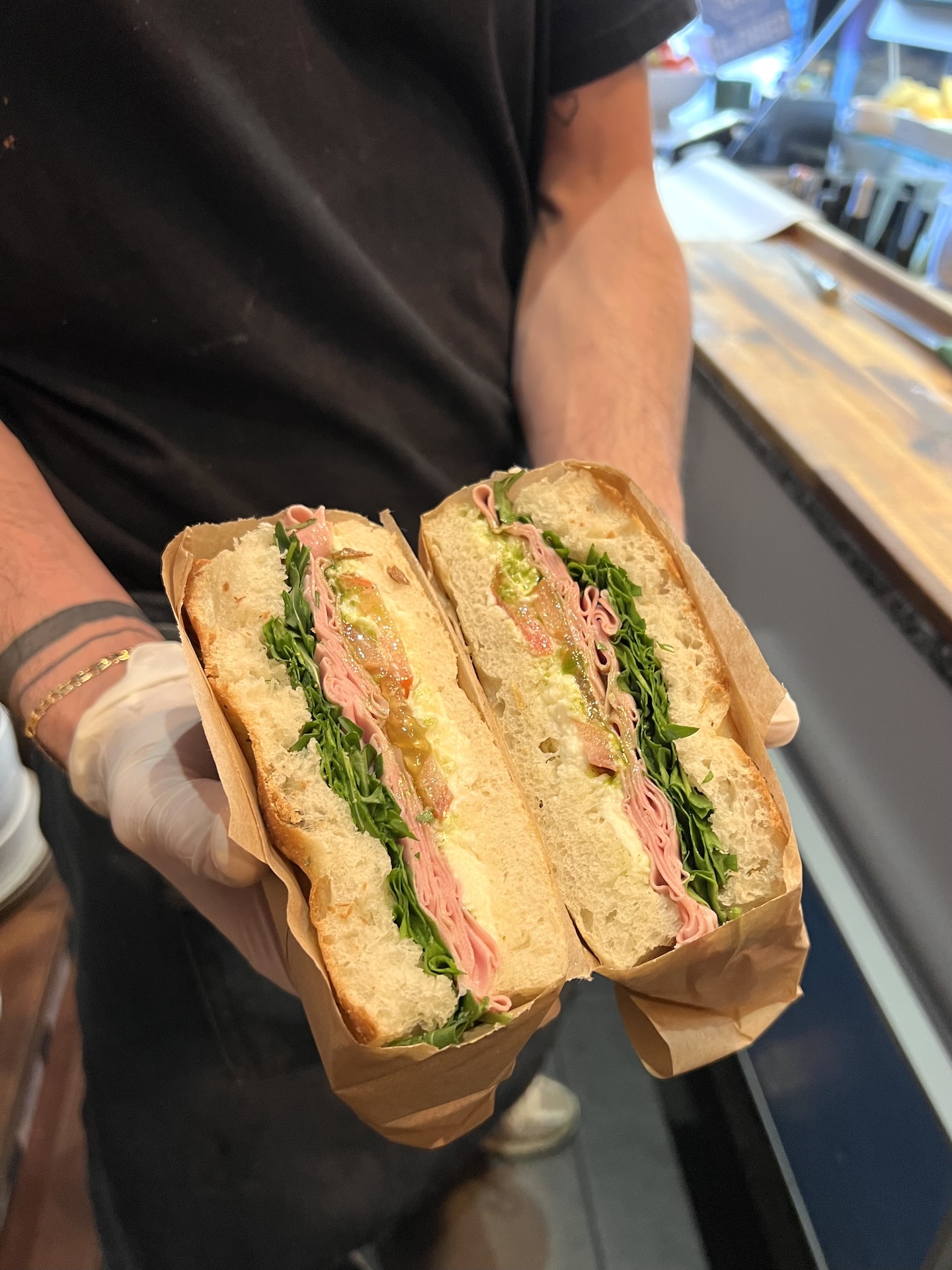 Focaccia ouverte et garnie de mortadelle, roquette, crème de burrata et tomates séchées
