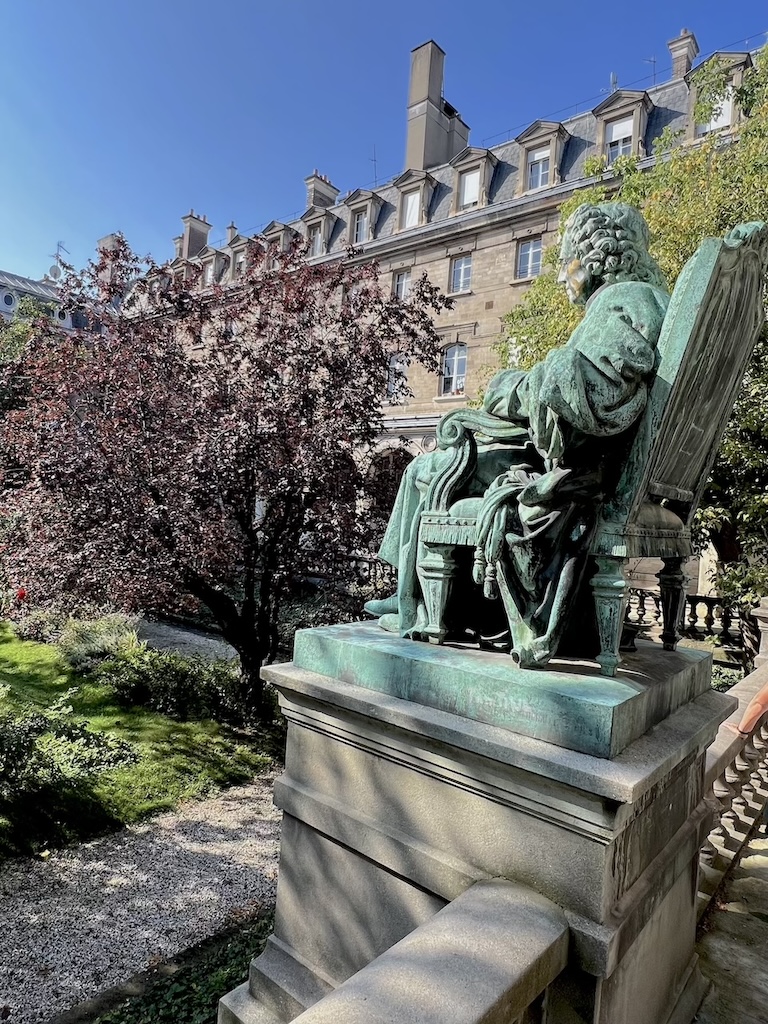 Cour d'Honneur du Lycée Jacques Decour avec une statue surplombant un jardin entouré de bâtiments.
