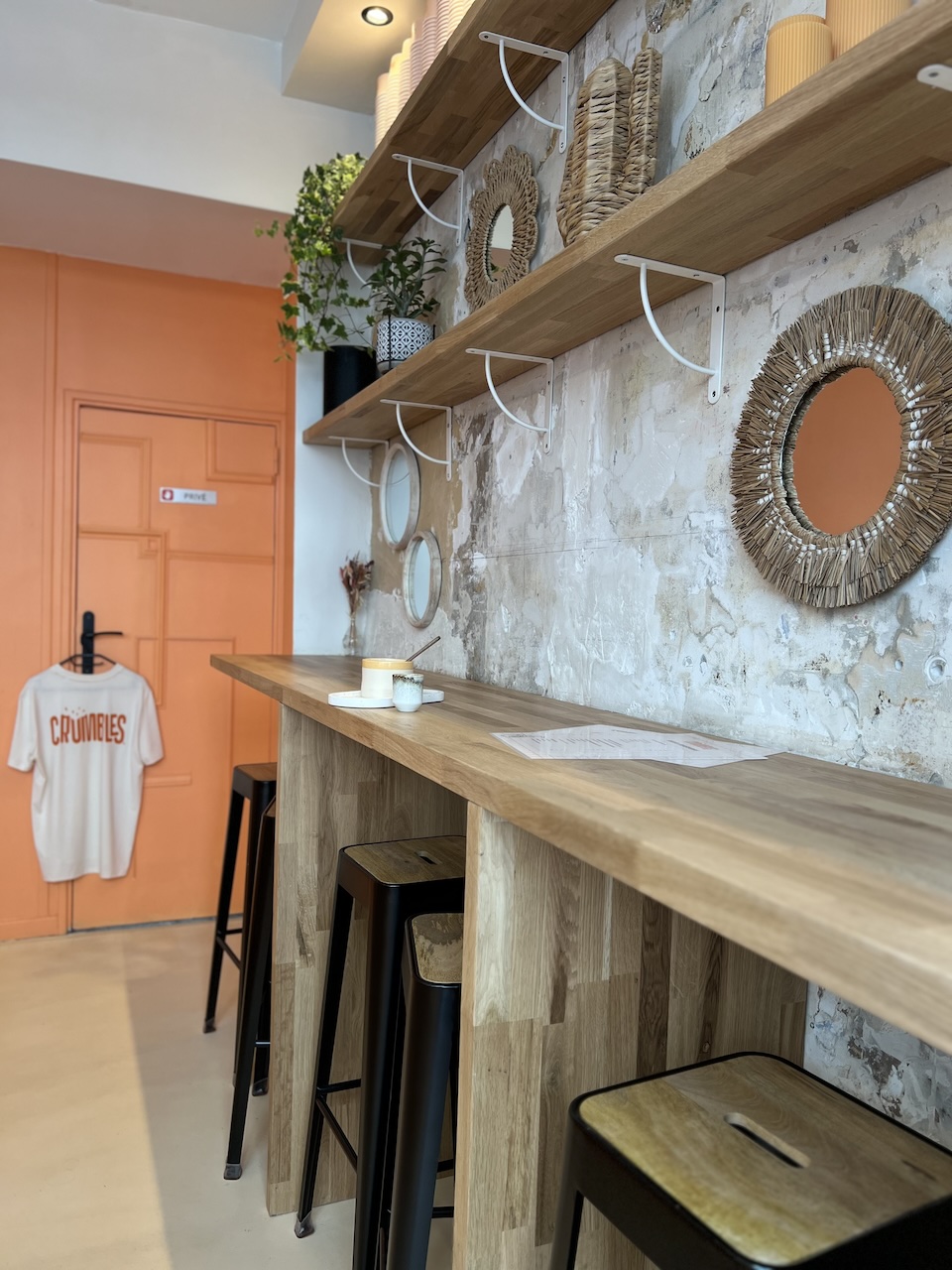 Intérieur de la boutique Crumbles avec du bois, et mur gratté.