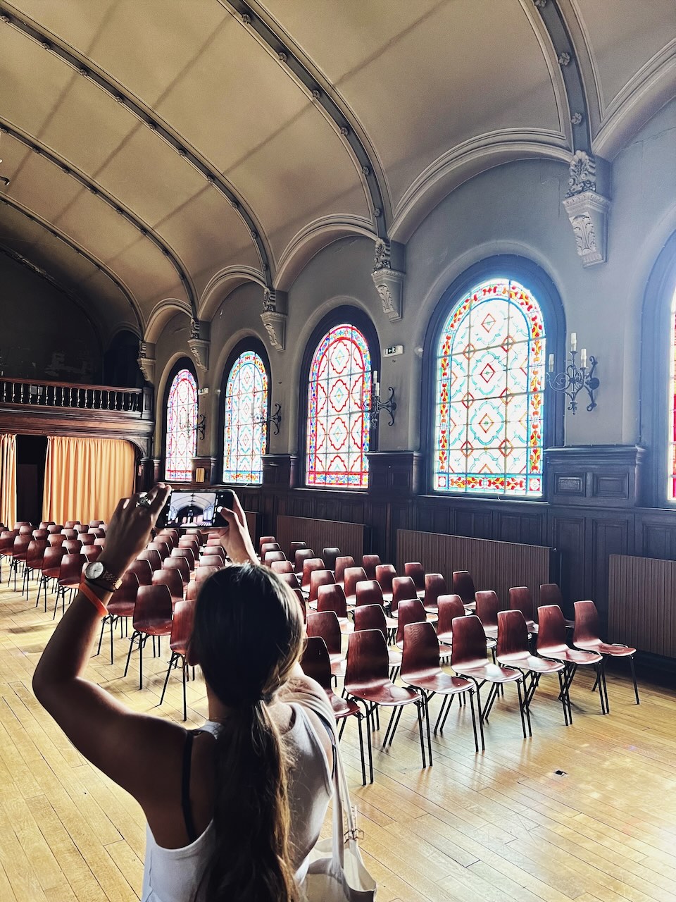 Une jeune fille prend en photo la chapelle et les vitraux de la cité scolaire Jacques-Decour