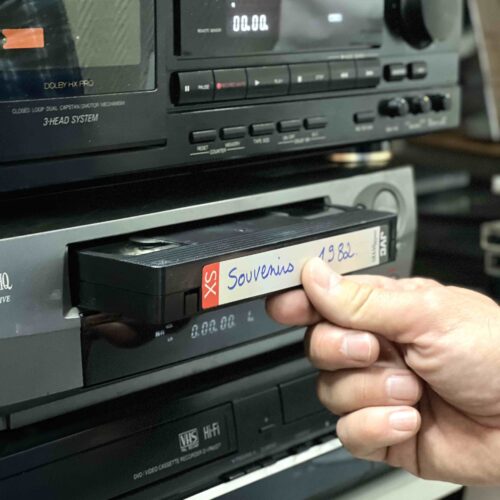 Mise en place d'une cassette VHS dans un magnétoscope.