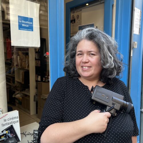 Murielle Levy, caméra DV au poing, devant sa boutique de numérisation d'archives