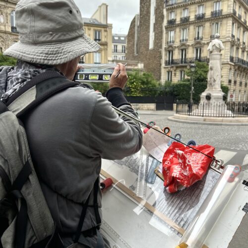 Christian Baillard utilise un niveau à bulle pour reproduire au dessin la place Saint Georges
